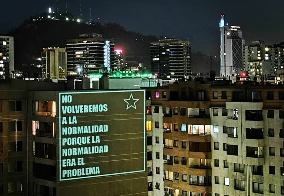 Projektion auf eine Hauswand in Chile: Wir werden nicht zur Normalität zurückkehren, weil die Normalität das Problem war!